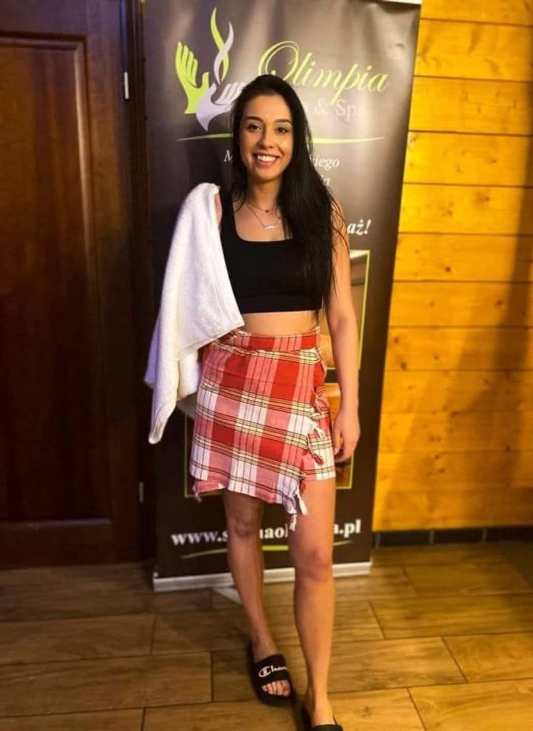 Prowadząca ceremonię saunową stojąca przed wejściem do Sauny Olimpia – zapowiedź Dnia dla Pań 26 lutego.